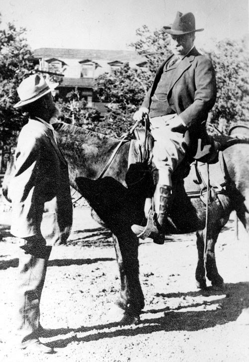 Teddy Roosevelt, mounted on a horse, speaking to John Hance