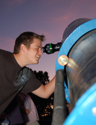 Young man enjoying the stars through a telescope.