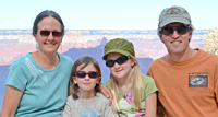 family of 4 with 2 girls in between parents, grand canyon in background