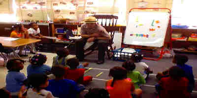 a picture of a ranger reading to a classroom of children