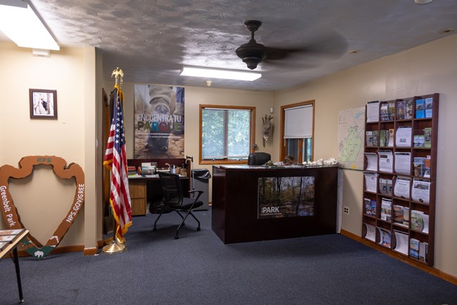 An information desk sits to the right of the ranger station surrounded by flag and brochures
