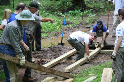 Volunteers helping repair a boardwalk on the Perimeter trail in Greenbelt Park.