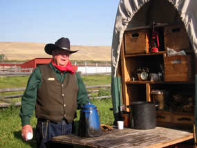 Chuckwagon cook standing by the chuckwagon.