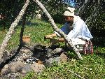 Canoe builder mixes pitch, charcoal and bear grease to use as sealant on a bark canoe.