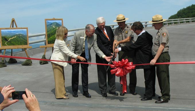 A group of officials cut the ribbon on the newly completed bridge.
