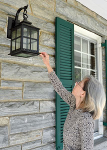 Cultural resources manager Dianne Flaugh indicates a restored historic light fixture in front of the park headquarters building.