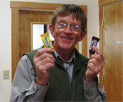 Preservation Specialist Greg Dodson holds two candy bars.
