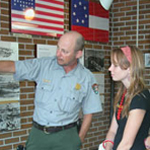 A ranger points to an exhibit so that   a young visitor can learn about the history of Fort Barrancas.