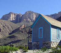 The lone ranch house stands isolated in its desert surroundings.