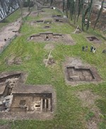 Aerial view of eight archeological digs with four archeologists on site at the location of the Harpers Ferry Armory along the floodplain of the Potomac River.