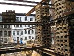 Large beams and jacks raise the building.