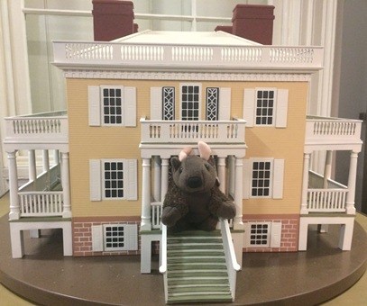 A bison stuffed animal on the front porch of a touchable miniature of Hamilton Grange.