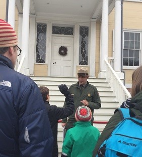 A park ranger stands among scouts in front of Hamilton Grange