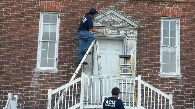 Workers removing lead paint from west side entrance