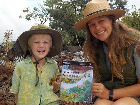 Eliot Carter and Ranger Katelyn Thomson display the park's new Junior Ranger Activity Book.