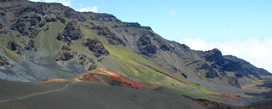Bright reds, yellows and greens brighten-up the summit landscape of brown, grey and black volcanic rock.