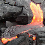 Lava flows down a slope and pools at the bottom.