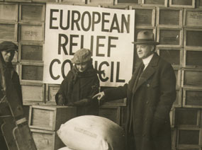 A man and women inspect relief supplies in front of European Relief Council sign.
