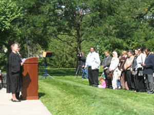 A judge addresses candidates for citizenship on the sunny grass lawn east of the Herbert Hoover Presidential Library and Museum.