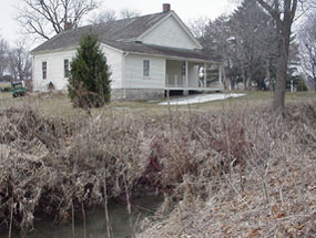 A creek runs just below the white frame meetinghouse.