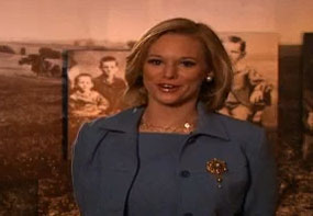 Screen capture of a woman speaking inside a museum gallery.