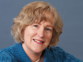 Photo portrait of a woman with blond hair, dressed in blue.