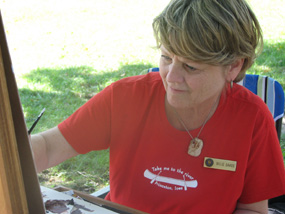A female artist paints in the shade of a tree on the grounds of Herbert Hoover National Historic Site. A female artist paints in the shade of a tree on the grounds of Herbert Hoover National Historic Site.