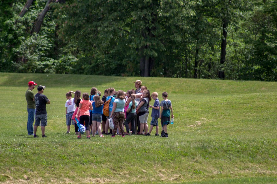 A ranger speaking to a group of visitors outdoors on a tour
