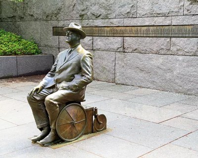 A bronze statue of FDR seated in a wheelchair