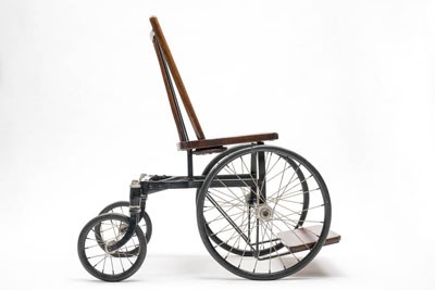 A wheelchair made of a steel wheel base attached to a common side chair.