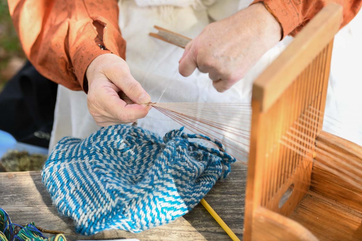 Hopewell Furnace Living History volunteer demonstrating how fabric was made