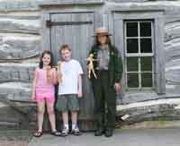 Ranger Alexis Winder and two young visitors and the Cornhusk Dolls they made