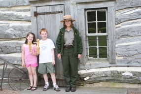 Young visitors pose with Park Ranger after making cornhusk dolls.