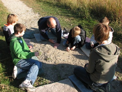 Children learning to play marbles.