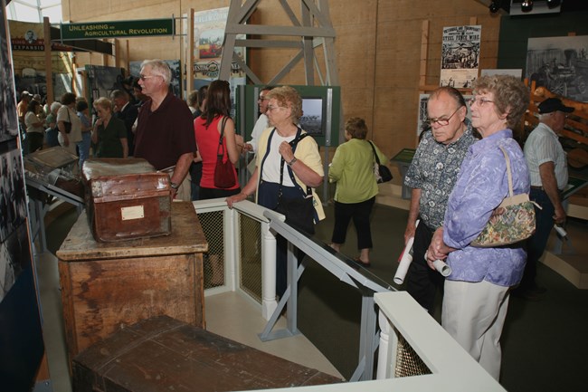 Visitors at the Heritage Center Museum look at historic traveling trunks.