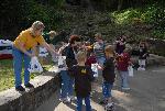 Park employees handing souvenir bags to children