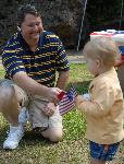 Man with toddler who is holding American flag