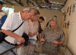 Two adults, park ranger look at glass exhibit case