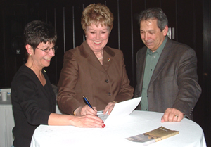 Superintendent Josie Fernandez, NPS
Director Mary Bomar, and NPS Midwest Region Director Ernie Quintana sign the lease on round table covered with white tablecloth. Superintendent Josie Fernandez, NPS
Director Mary Bomar, and NPS Midwest Region Director Ernie Quintana sign the lease on round table covered with white tablecloth.