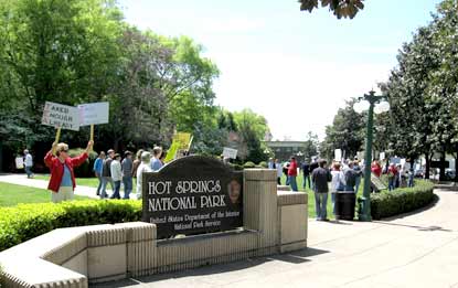 Group of people holding signs on park's Arlington Lawn at the entrance to the cascade area.