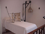 The men's massage room with a narrow bed covered with a white sheet,