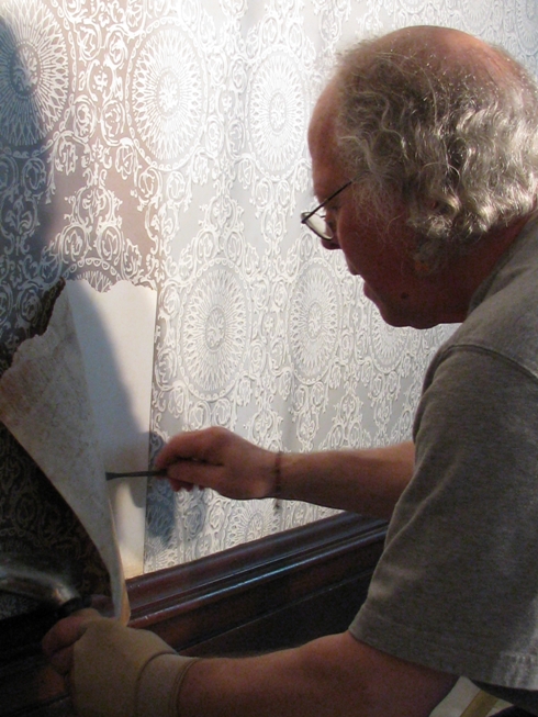 Tom Edmondson, Conservator, removes historic wallpaper from Truman Home dining room.