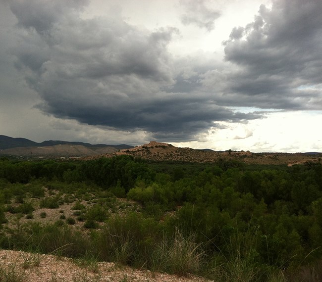 Dark clouds gather over a desert butte.