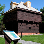 Wood blockhouse with sign in foreground