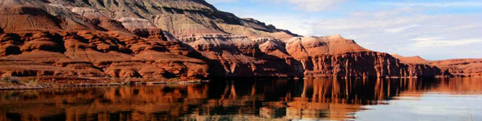 Red cliffs descend into the water of Bighorn Canyon