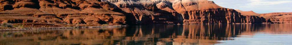 Red cliffs descend into the water of Bighorn Canyon