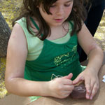 A park visitor scratches her own 'petroglyph' into a plaster 'rock'