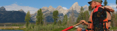 visitor on a Snake River float trip with Teton Range in background