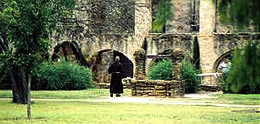 Franciscan Brother walking in the ruins of Mission San José's convento