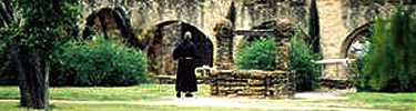 Franciscan Brother walking in the ruins of Mission San José's convento